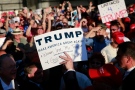 Republican presidential candidate Donald Trump, centre, holds up a sign after autographing it during a rally at the Sacramento International Jet Center, Wednesday, June 1, 2016, in Sacramento, Calif. (AP Photo/Jae C. Hong)