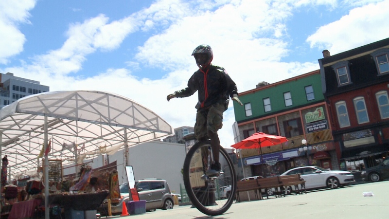 Paul Abraham peddles his unicycle in the Byward Market in Ottawa, June 6, 2016