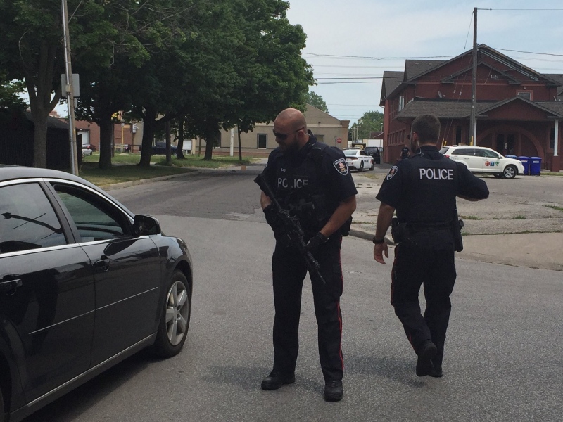Police guns are drawn as officers investigate a shooting on Wyandotte Street East in Windsor, Ont., on Wednesday, June 22, 2016. (Sacha Long / CTV Windsor)