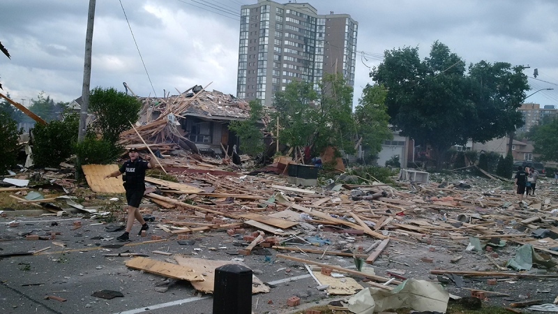 Debris litters a street after a house explosion in Mississauga, Ont., Tuesday, June 28, 2016. (Zeljko Zidaric / THE CANADIAN PRESS)