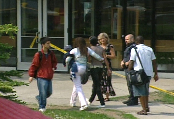 Students and parents entering C.W. Jefferys Collegiate Institute are greeted by a grief counsellor and police officer on Thursday, May 24, 2007.