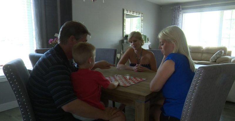 Nicole Edison, right, and Karen Begbie, centre, play a board game in their Barrie, Ont. home on Monday, July 18, 2016. (CTV Barrie)
