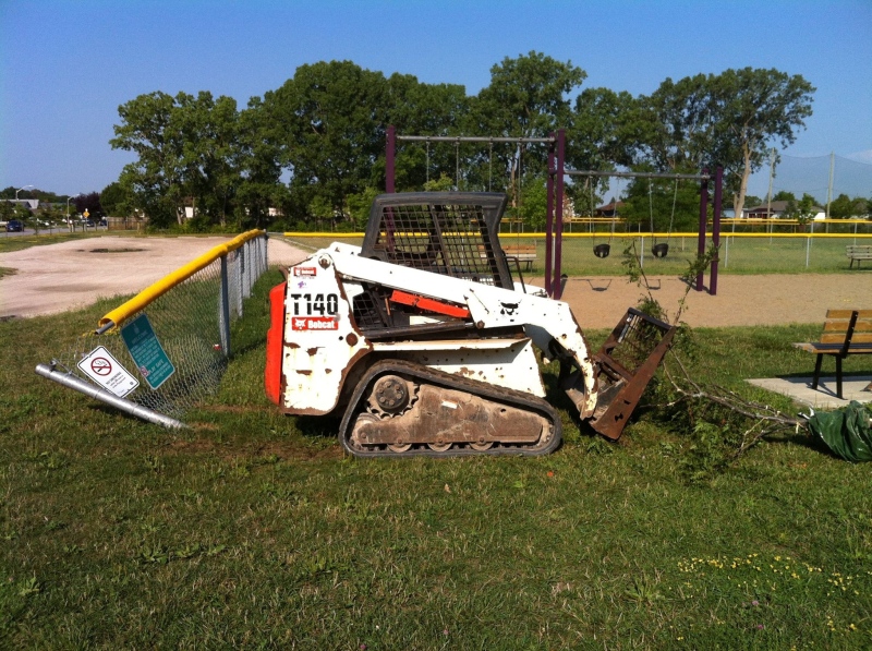 Police are investigating after a bobcat crushed a small tree and fence at Walkerville Homesite playground in Windsor, Ont. (Courtesy Mark Jones / Facebook)