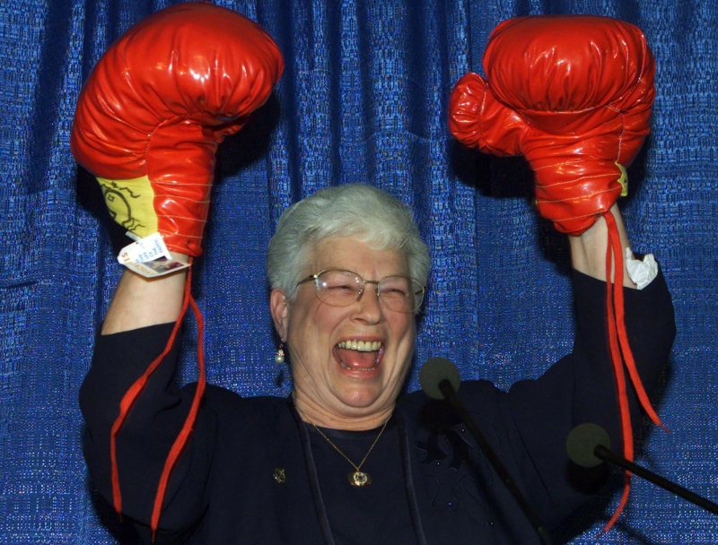 In this file photo, then-Conservative candidate for Saint John, Elsie Wayne, raises her hands after receiving a pair of boxing gloves from a man dressed in a blue Santa suit during her nomination meeting in Saint John, N.B. Monday Oct. 23, 2000. (THE CANADIAN PRESS/Jacques Boissinot)