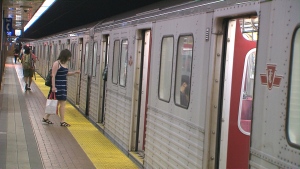 A woman boards a Line 2 subway car on a hot day. 