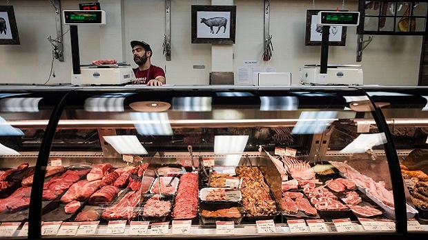 A butcher at Sanagan's Meat Locker butcher shop in Toronto weighs product to be sold on Saturday, September 10, 2016. (THE CANADIAN PRESS/Christopher Katsarov)