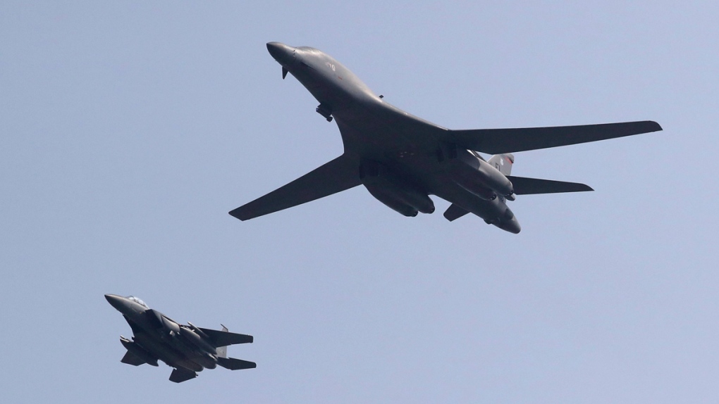 U.S. B-1B bomber, right, flies over Osan Air Base