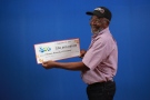 Kitchener resident Ashman Kennedy holds the $30-million cheque he received for winning a Lotto Max jackpot. (Ontario Lottery and Gaming Corp.)