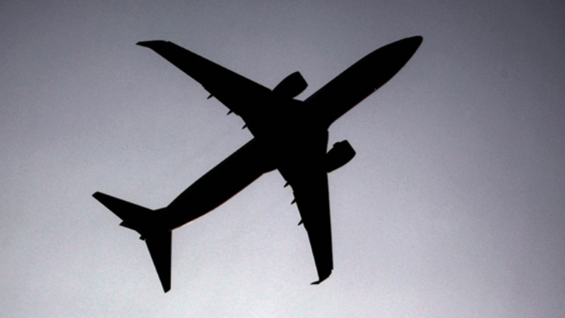 A silhouette of an airplane flying overhead. (AP)