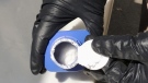 In this June 27, 2016 photo provided by the Royal Canadian Mounted Police, a member of the RCMP opens a printer ink bottle containing the opioid carfentanil imported from China, in Vancouver.