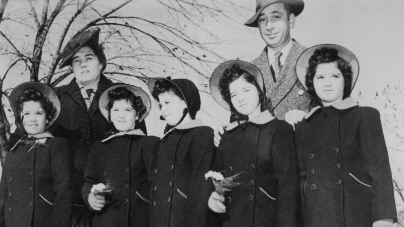 Elzire and Olivia Dionne stand with their quintuplets, Cecile, Yvonne, Marie, Emilie and Annette in this undated photo. (THE CANADIAN PRESS)