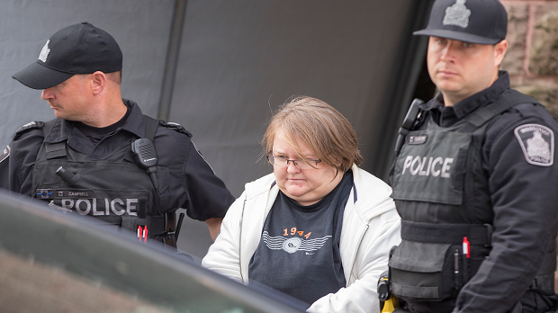 Elizabeth Tracey Mae Wettlaufer is led out of court by Toronto police officers on Oct. 25, 2016. (Geoff Robins/The Globe and Mail)