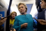 Democratic presidential candidate Hillary Clinton, accompanied by travelling press secretary Nick Merrill, right, and Director of Communications Jennifer Palmieri, left, takes a question from a member of the media aboard her campaign plane, Wednesday, Oct. 26, 2016, while travelling to Westchester. Clinton turns 69 today. (AP Photo/Andrew Harnik)