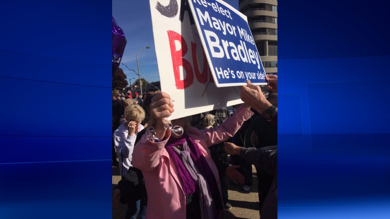 A pro-Mike Bradley protester holds a campaign sign up to Sarnia Coun. Cindy Scholten's sign that states, "Say No To Bullying" during a rally on Oct. 28, 2016. (Bryan Bicknell/CTV)