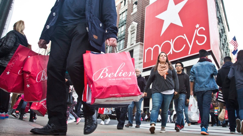 In this Friday, Nov. 27, 2015, file photo, shoppers carry bags as they cross a pedestrian walkway near Macy's in Herald Square, in New York. (AP / Bebeto Matthews)