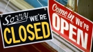 File photo of 'we're open' and closed signs.