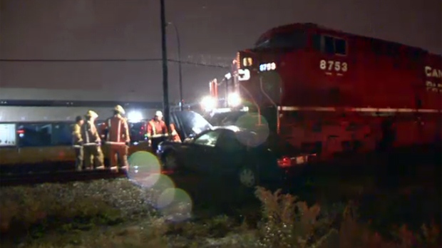 Emergency crews look at a car hit by a train