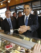 U.S. President Barack Obama tries to pay for some Canadian Maple Leaf cookies, seen in display case, below, as he makes an unannounced visit to a market in Ottawa,  Thursday, Feb. 19, 2009. (AP / Charles Dharapak)