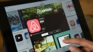 A woman browses the site of U.S. home sharing giant Airbnb on a tablet. (AFP / John Macdougall)