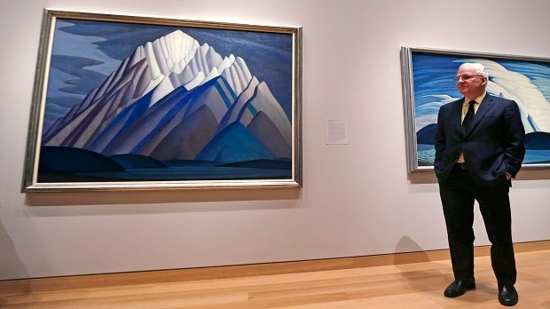 Actor and comedian Steve Martin, who is guest curator of an exhibition at the Museum of Fine Arts devoted to Canadian modernist Lawren Harris, stands next to Harris's "Mountain Forms" painting during a gallery preview at the museum in Boston, Friday, March 11, 2016. (AP Photo/Charles Krupa)