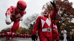 A balloon operator waves to spectators while guiding the Red Ranger balloon along West Central Park during the Macy's Thanksgiving Day parade, Thursday, Nov. 24, 2016, in New York. (AP / Julie Jacobson)