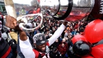 Ottawa RedBlacks Nick Taylor raises the Grey Cup over his head as he rides on a float at a parade celebrating the team's victory over the Calgary Stampeders, Tuesday, Nov. 29, 2016 in Ottawa. (Justin Tang / THE CANADIAN PRESS)