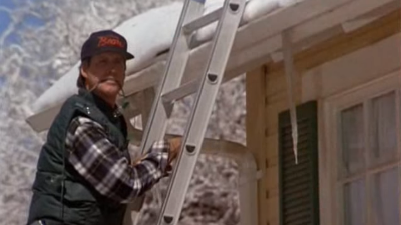 Clark Griswold, played by Chevy Chase, hangs holiday lights in this scene from the 1989 film "National Lampoon's Christmas Vacation." (Warner Bros.) 