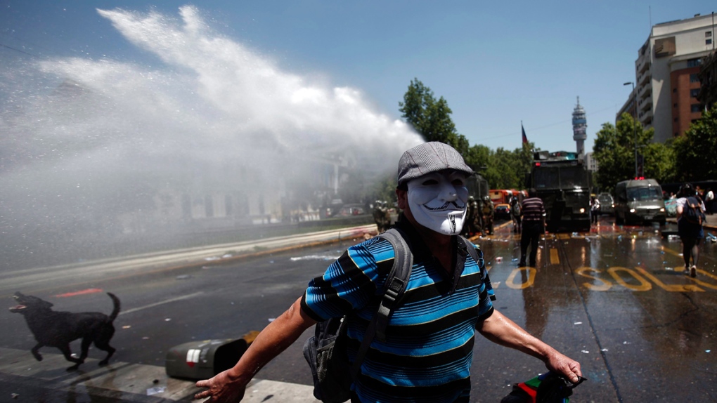 Police use a water cannon in Santiago, Chile
