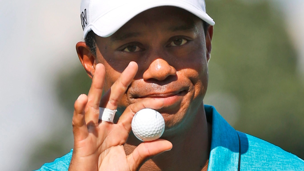 Tiger Woods tips his ball to the gallery