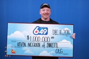Kevin McGrath holds his winning $1 million cheque at the OLG office in Toronto, Ont. on Friday, Dec. 16, 2016. (OLG)