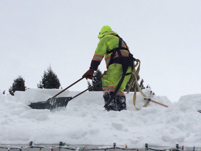 A man clears a roof of snow in Barrie, Ont. on Tuesday, Dec. 20, 2016. (Rob Cooper/ CTV Barrie)