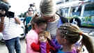 Courtney Gelinas, left, is hugged by her mother Kim Lariviere, center, after being reunited with her stuffed bear Rufus, at the Fort Lauderdale-Hollywood International Airport, Tuesday, Jan. 10, 2017, in Fort Lauderdale, Fla. Gelinas, of Windsor, Ontario, Canada, was traveling home with her family after a Caribbean cruise. They became separated from their belongings as they fled during last week's shooting at the airport in which five people were killed. At right is Kim's sister Kacie Gelinas. (AP Photo/Lynne Sladky)