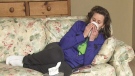 In this undated file photo, a woman suffers through a cold at home. 
