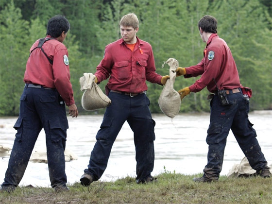 Forest firefighters from Northern B.C. work on building a sandbag dike along the banks of the Bulkley River in Telkwa, B.C. Thursday June 7, 2007. (CP / Chuck Stoody)