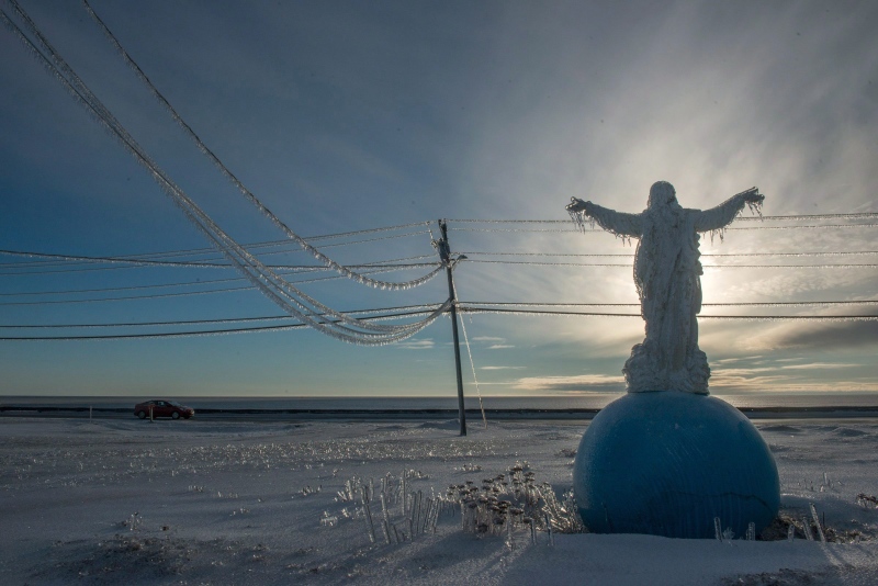 A statue at the Pointe Sapin Church facing the Northumberland Strait is covered in ice in Pointe-Sapin N.B., Thursday, Jan.26, 2017. (Diane Doiron / THE CANADIAN PRESS)