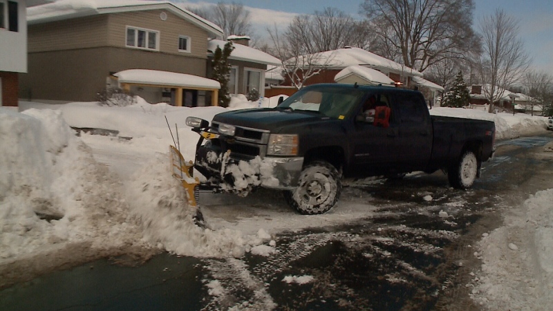A snowplow removes the snow from a driveway in Nepean on Wednesday. The capital has received 245 cm of snow this winter, five away from most snow removal companies charging more. (Chris Scott/CTV Ottawa, February 15, 2017)