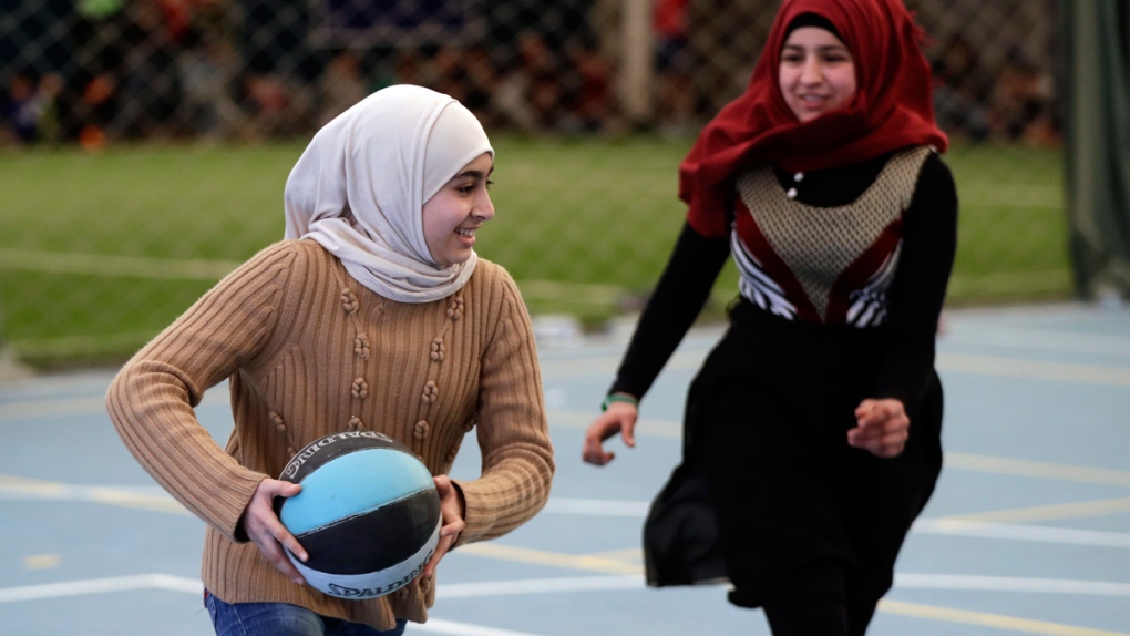 Syrian refugee girls play a basketball game
