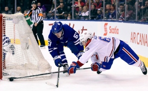 Toronto Maple Leafs' Jake Gardiner (51) gives chase as Montreal Canadiens' Artturi Lehkonen (62) dives for control of the puck during third period NHL action, in Toronto on Saturday, February 25, 2017. THE CANADIAN PRESS/Frank Gunn