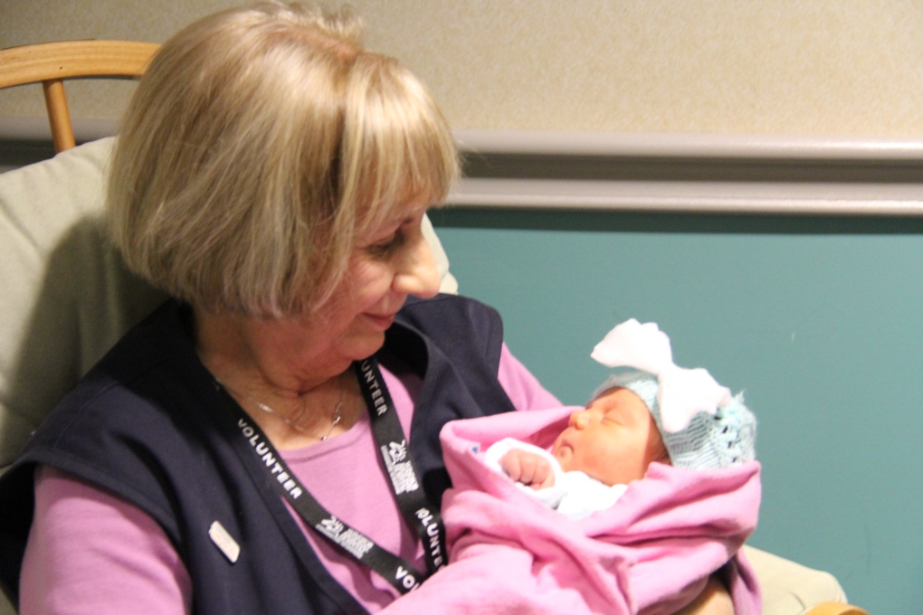 Volunteer Diana Learn cuddles baby Evelina 