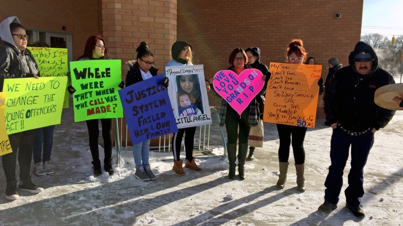 Family members of Nikosis Jace Cantre, a six-week-old boy killed in July 2016, hold posters outside Saskatoon Provincial Court on Wednesday, March 8, 2017. The family is calling for the teen girl who killed the baby to be sentenced as an adult. (Mark Villani/CTV Saskatoon)