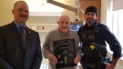 Pte. Stephen Smith of the Royal Canadian Legion (left) and Const. Kevin DeClark of Woodstock Police (right) present a replacement set of military pins and service medals to Jim Wettlaufer.