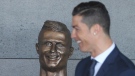 Cristiano Ronaldo with a bust in his likeness at the Madeira international airport outside Funchal on March 29, 2017. (Armando Franca / AP)