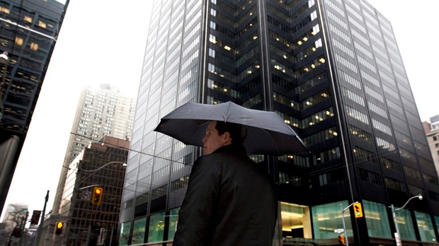 A man hides under an umbrella while walking in downtown Toronto Thursday, March 10, 2011. THE CANADIAN PRESS/Darren Calabrese