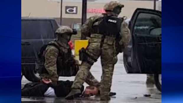 RCMP officers arrest a man in a parking lot on Pinebush Road in Cambridge.