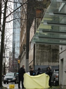 Police officers assist the coroner in removing a body after a man was shot and killed by police in Vancouver, B.C., on Friday, March 20, 2009. (CP/Darryl Dyck)