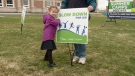 Kanata Academy student Julia Billie places a sign in the front lawn of her school encouraging drivers to slow down  on Thurs. April 20, 201