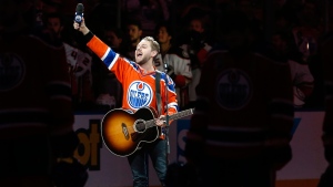 Canadian country singer Brett Kissel holds his faulty microphone asking the crowd to sing the "Star-Spangled Banner" before the start of the Anaheim Ducks and the Edmonton Oilers NHL hockey round two playoff hockey game in Edmonton, Sunday, April 30, 2017.THE CANADIAN PRESS/Jeff McIntosh