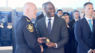 Former BC Lions receiver Shawn Gore accepts his badge from Chief Adam Palmer at a Vancouver Police Department recruiting ceremony. May 4, 2017. (CTV)