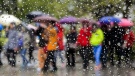 People brace for a stint of rainfall in Toronto. (Markus Schreiber/AP Photo)