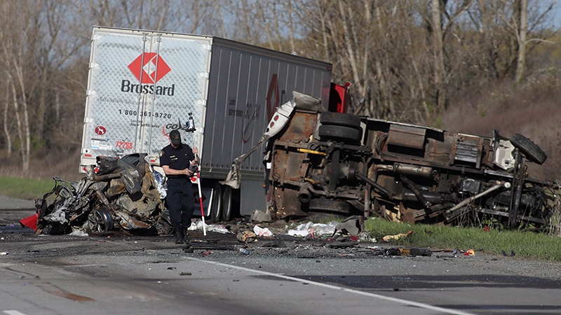 An OPP officer attends the site of a crash in the westbound 401, northeast of Kingston, Ont. early Thursday May 11, 2017. (THE CANADIAN PRESS/Lars Hagberg)